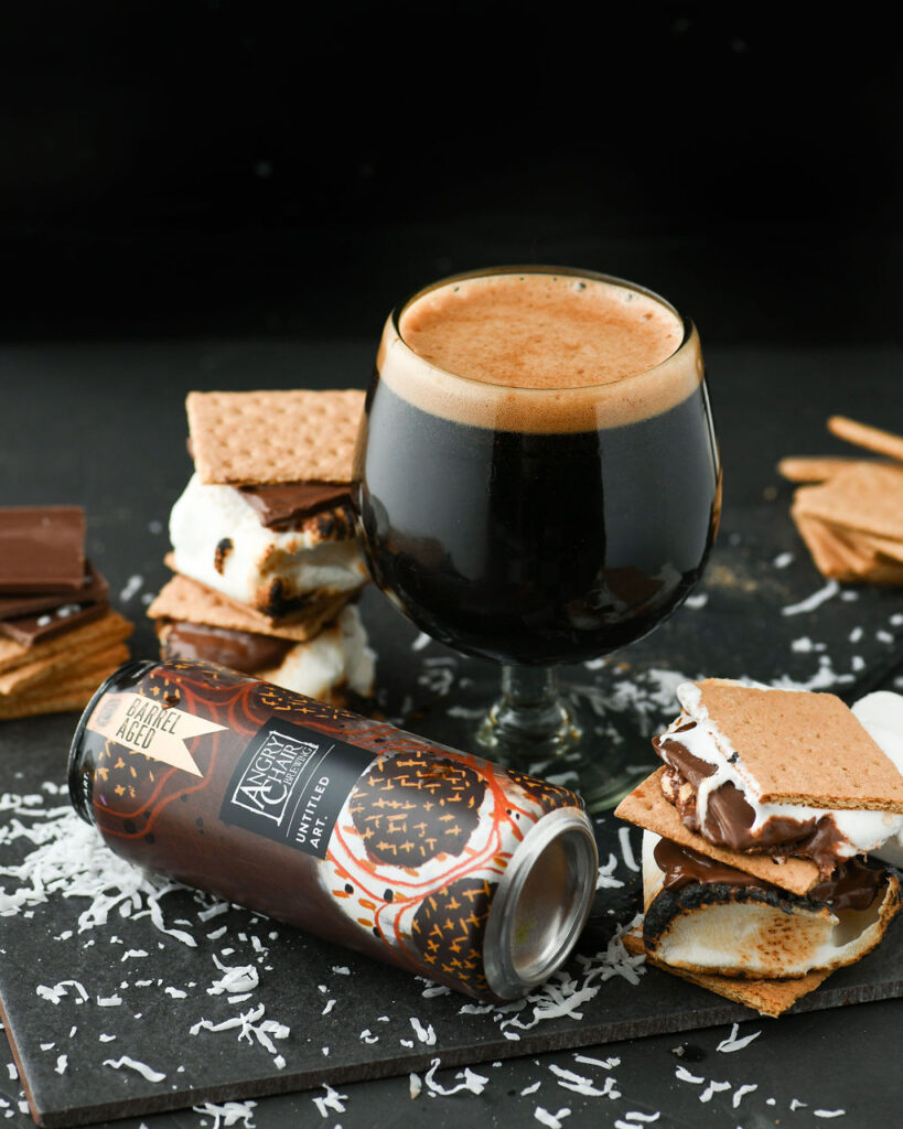A glass of black beer with marshmallows and graham crackers.